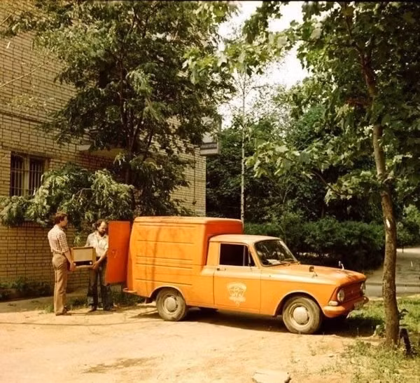 Hai người đàn ông khiêng đồ lên một chiếc xe tải nhỏ. Ảnh: ER.