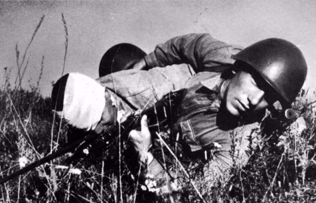 Một người lính Hồng quân Liên Xô cố đưa đồng đội bị thương ra khỏi chiến trường trong trận đánh Stalingrad năm 1942. Ảnh: VT.