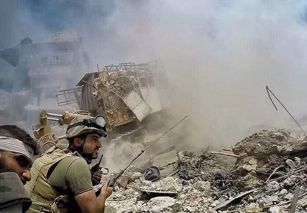 Một binh sĩ liên lạc qua bộ đàm giữa khung cảnh đổ nát ở Đông Damascus. Ảnh: FNA.