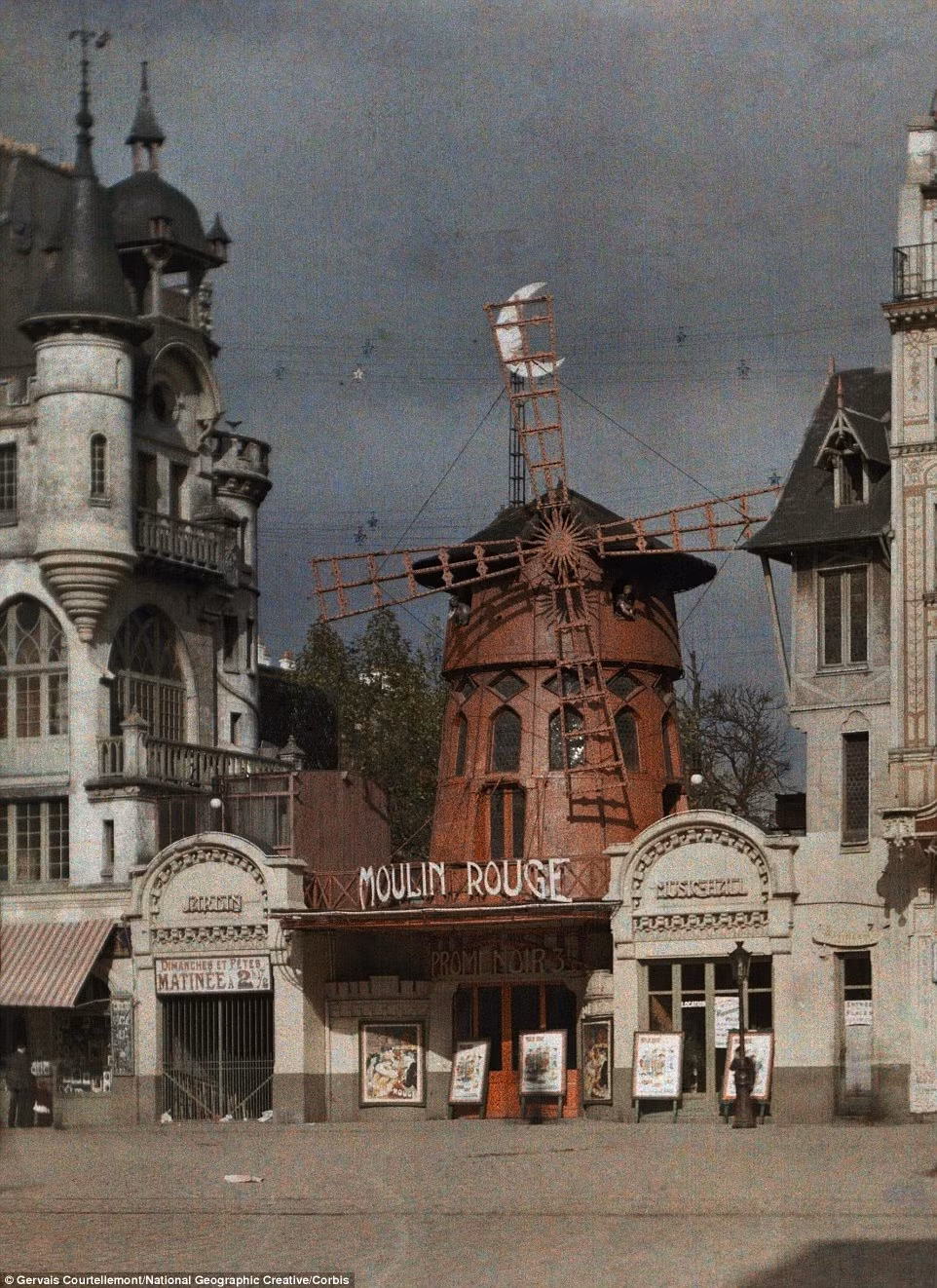 Quán rượu Moulin Rouge nổi tiếng ở Paris, Pháp đặt nhiều áp phích quảng cáo phía trước quán, thu hút sự chú ý của người đi đường.