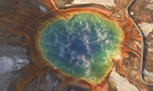 Tên gọi của The Grand Prismatic Spring - suối nước nóng lớn nhất Mỹ được đặt theo màu sắc nổi bật mà chúng hòa quyện bao gồm: xanh da trời, xanh lá cây, vàng, cam, vàng, đỏ và nâu, gần giống như một dải cầu vồng rực rỡ. Nguyên nhân khiến suối phun này có màu sắc ấn tượng như vậy là do các thảm vi khuẩn sắc tố phát triển trong dòng nước giàu khoáng chất và độ sặc sỡ của suối cũng phụ thuộc vào tỷ lệ chất diệp lục và thời tiết.