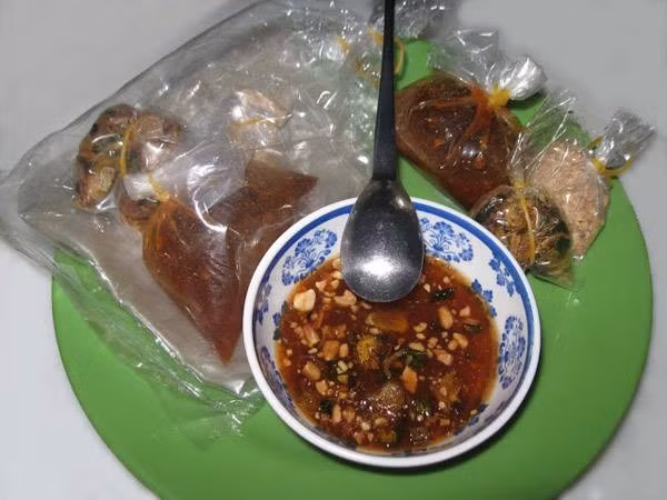 Bánh tráng me Tây Ninh: Bánh tráng me vốn luôn được gia giảm nguyên liệu rất tùy hứng nhưng cái vị chua của nước me chín, vị cay xé của ớt, vị béo giòn của đậu phộng rang tạo nên một hương vị quyến rũ, khó quên.