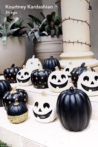 Kourtney Kardashian trang trí trước hiên nhà với bí ngô hình mặt người đen trắng. Ảnh: Saovui.