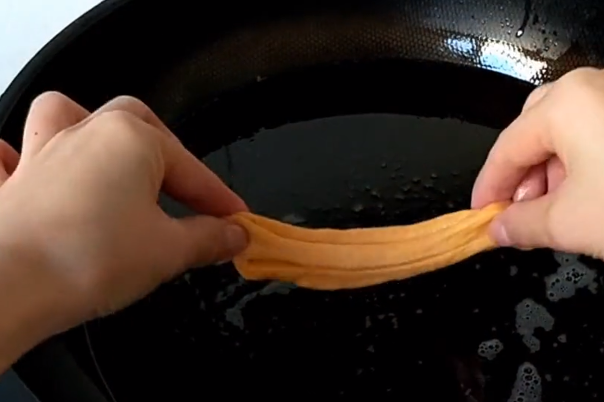 Cho dầu vào chảo đun nóng rồi thả các miếng bột vào.