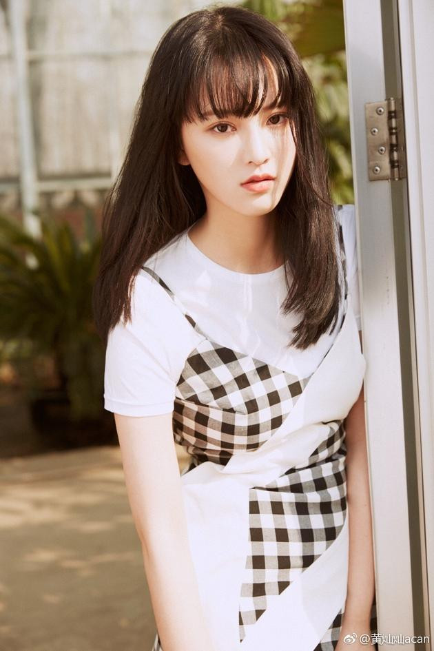 Váy dây mặc ngoài áo phông trắng mang lại vẻ đẹp vừa nữ tính, thơ ngây, như một nàng búp bê cho Nữ thần Vũ Hán,