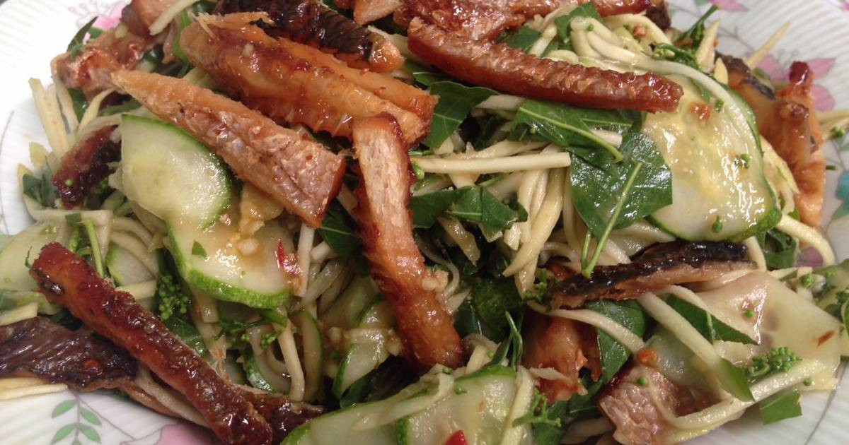 Lá sầu đâu được trần qua nước sôi và kết hợp cùng với các loại nguyên liệu khác như thịt ba chỉ, tôm, cá khô xé nhỏ, xoài xanh dưa chuột,... Ảnh: cpcdn.