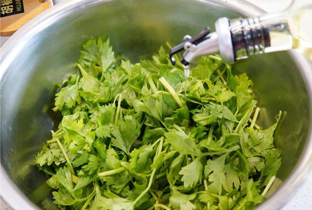 Bước 2: Thêm 1 muỗng dầu trộn salad vào lá cần tây đã xử lý để khóa hàm lượng nước của lá cần tây, trộn đều.