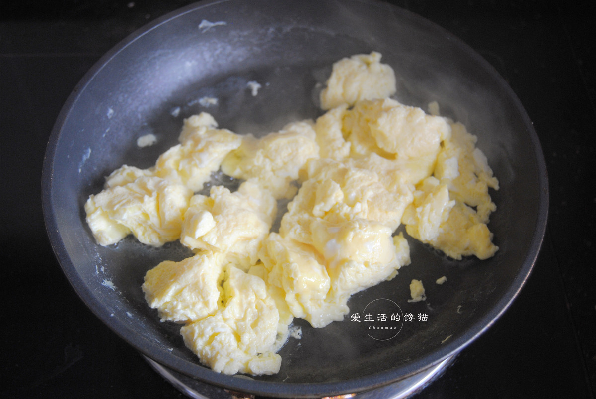 Dùng thìa cắt trứng thành miếng nhỏ, rán cho đến khi tất cả trứng đều vàng, sau đó rắc hành lá xắt nhỏ và đảo đều.