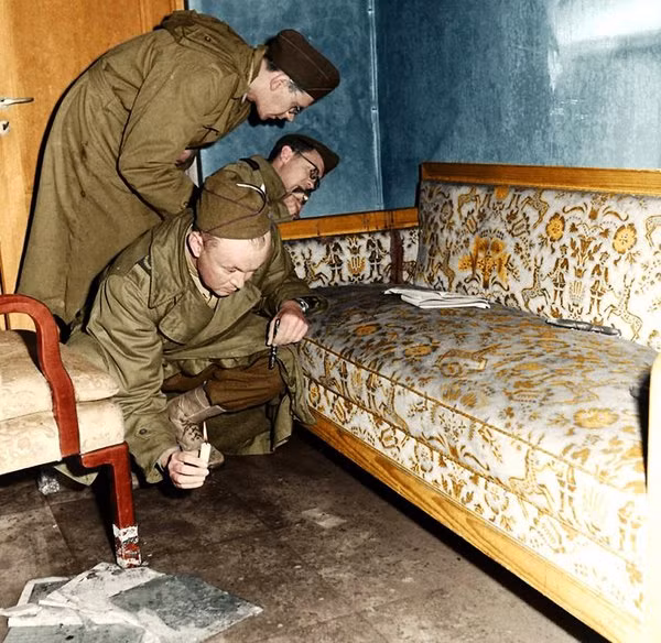 Các phóng viên chiến tranh, binh sĩ, chuyên gia Liên Xô dùng nến để rọi đường, kiểm tra chiếc ghế sofa nhuốm máu ở bên trong boongke của Hitler. Chiếc ghế sofa này chính là nơi Hitler và Eva tự bắn mình.