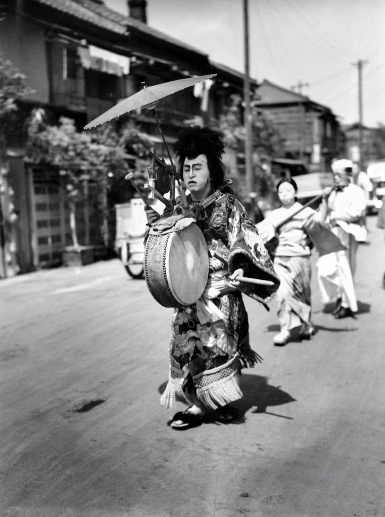 Các vũ công diễu hành trên phố trong trang phục truyền thống để quảng cáo cho nhà hàng mới mở ở Tokyo, 14/2/1947.