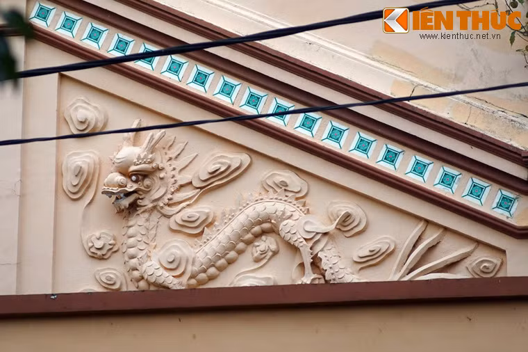 Ở hai bên, phía trên cửa sổ có đắp nổi hình 2 con rồng uốn khúc quay mặt vào nhau.