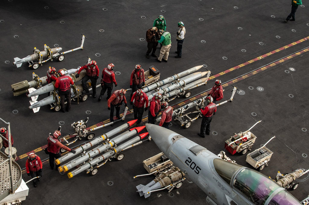 Các kỹ thuật viên chuẩn bị vũ khí cho tiêm kích F/A-18E/F Super Hornet làm nhiệm vụ. Hải quân Mỹ nhận thấy rằng việc điều động tàu sân bay đi qua eo biển Hormuz khi Tổng thống Trump tăng sức ép với Tehran có thể kích động cuộc xung đột mà Lầu Năm Góc muốn tránh. Ảnh: New York Times.