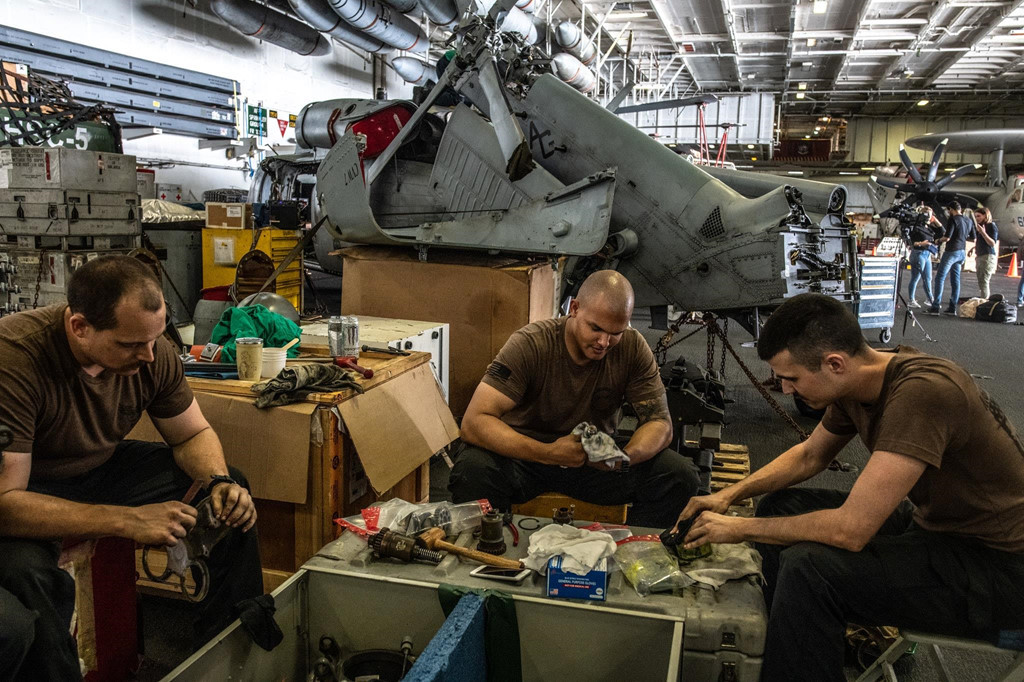 Các kỹ thuật viên bảo trì máy bay bên trong nhà chứa. Hải quân Mỹ nhận lệnh từ tổng thống để đối phó với Iran ở Trung Đông, nhưng theo cách ít khiêu khích nhất. Thuyền trưởng William Reed, chỉ huy không quân trên tàu Lincoln, nói với New York Times: "Chúng tôi không muốn leo thang với Iran". Ảnh: New York Times.