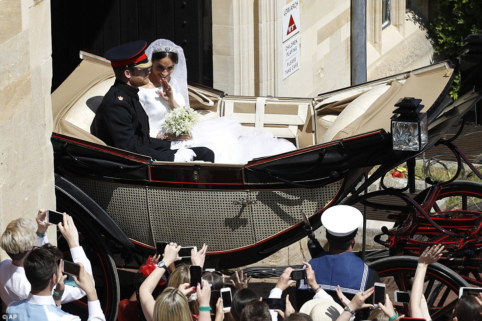 Đám đông người hâm mộ reo hò khi cỗ xe ngựa chở cặp đôi Harry-Markle đi qua. Ảnh: AP.