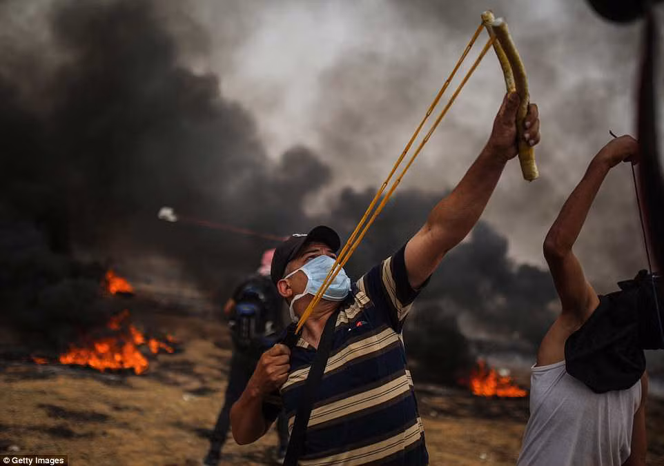 Một số người Palestine dùng nỏ bắn đá về phía lực lượng an ninh Israel.