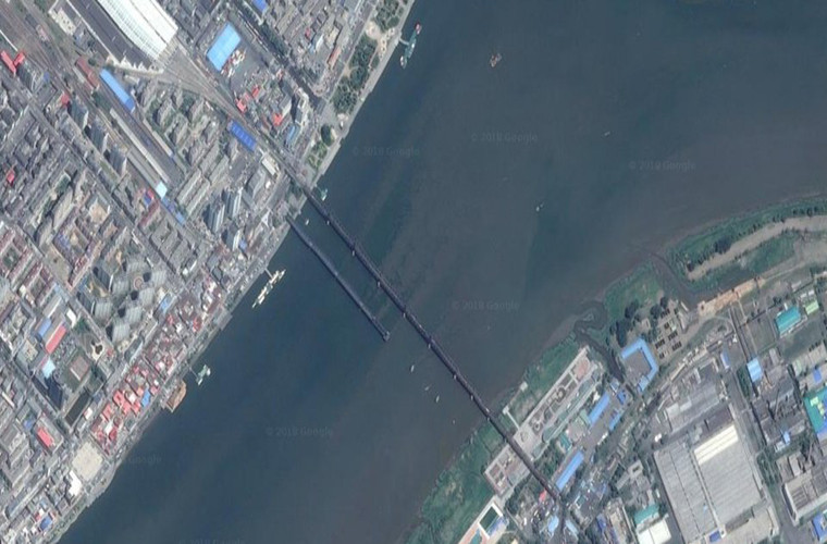 Trước đây từng có một cây cầu nữa nối liền hai quốc gia này nhưng nó đã bị hư hại sau lần Không quân Mỹ ném bom vào năm 1950 và vẫn chưa được sửa chữa. Cây cầu này còn được gọi là Cầu Đoạn (Broken Bridge). Ảnh: Hai cây cầu bắc qua sông Áp Lục nhìn từ trên cao.