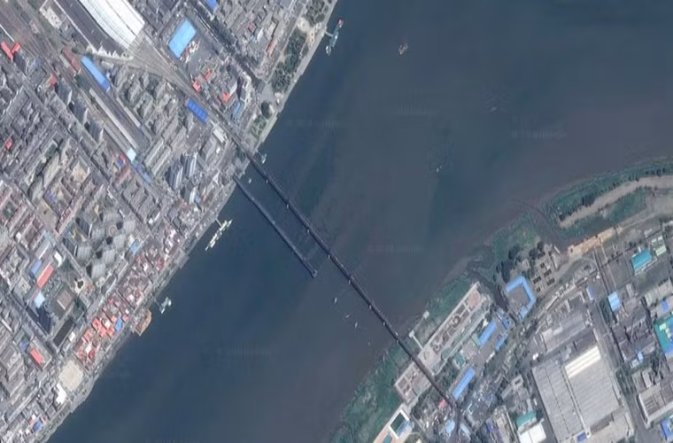 Trước đây từng có một cây cầu nữa nối liền hai quốc gia này nhưng nó đã bị hư hại sau lần Không quân Mỹ ném bom vào năm 1950 và vẫn chưa được sửa chữa. Cây cầu này còn được gọi là Cầu Đoạn (Broken Bridge). Ảnh: Hai cây cầu bắc qua sông Áp Lục nhìn từ trên cao.