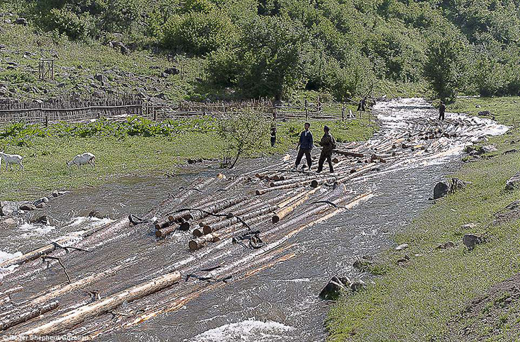 Những người đàn ông đi qua con suối ở làng Daejeonpyeong-ri, huyện Unhung, tỉnh Ryanggang-do.