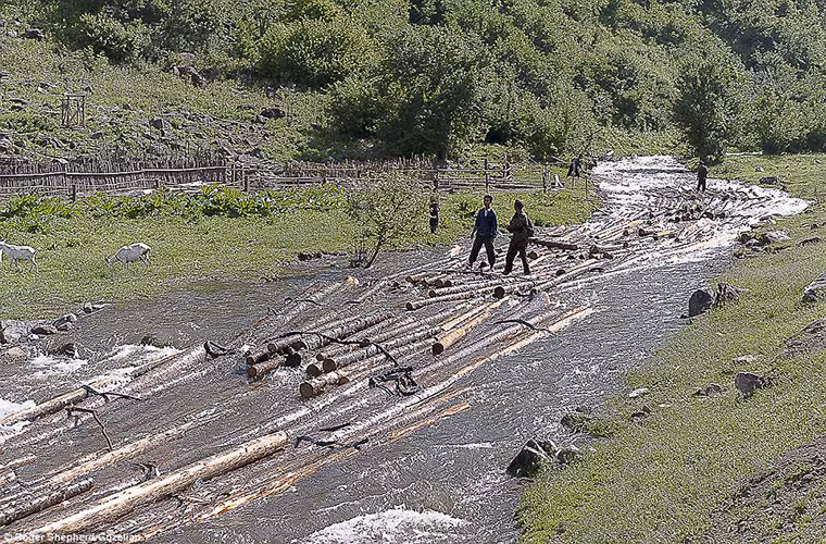 Những người đàn ông đi qua con suối ở làng Daejeonpyeong-ri, huyện Unhung, tỉnh Ryanggang-do.