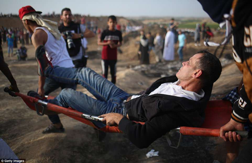 Một người đàn ông bị thương được đưa ra khỏi khu vực xung đột giữa Israel và Palestine. Ảnh: Getty.