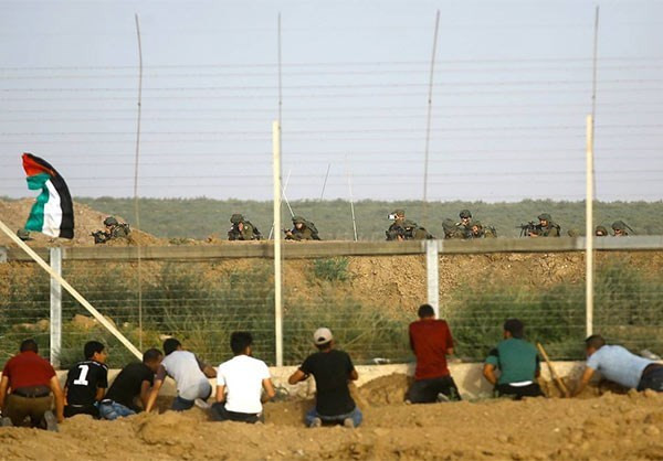 Những người biểu tình Palestine “chạm trán” với lực lượng an ninh Israel ở hàng rào biên giới. Ảnh: FNA.