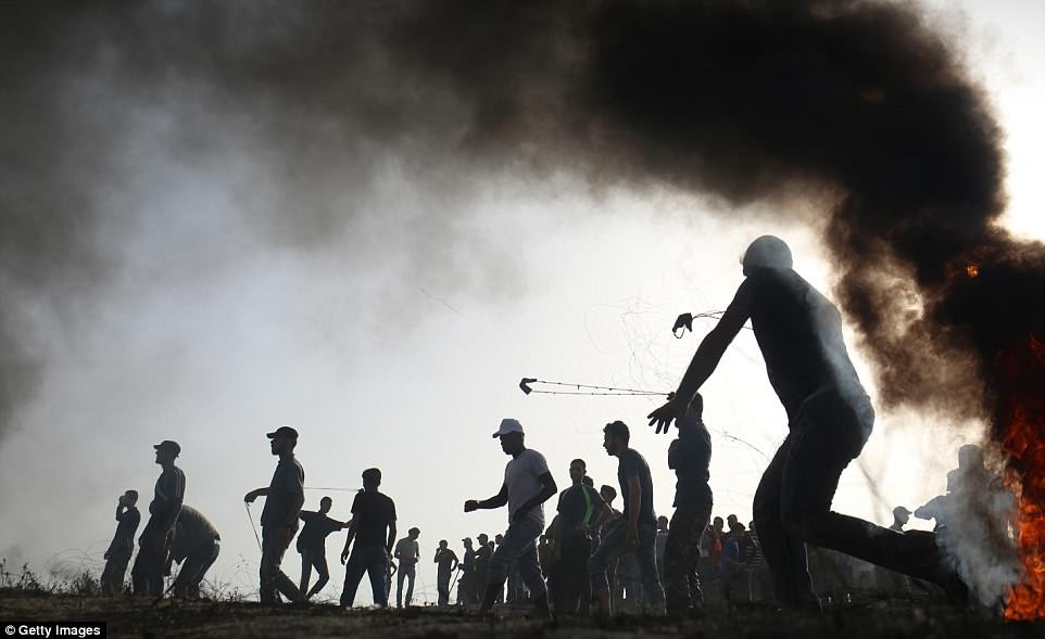 Người biểu tình Palestine ném đá về phía lực lượng an ninh Israel. Ảnh: Getty.