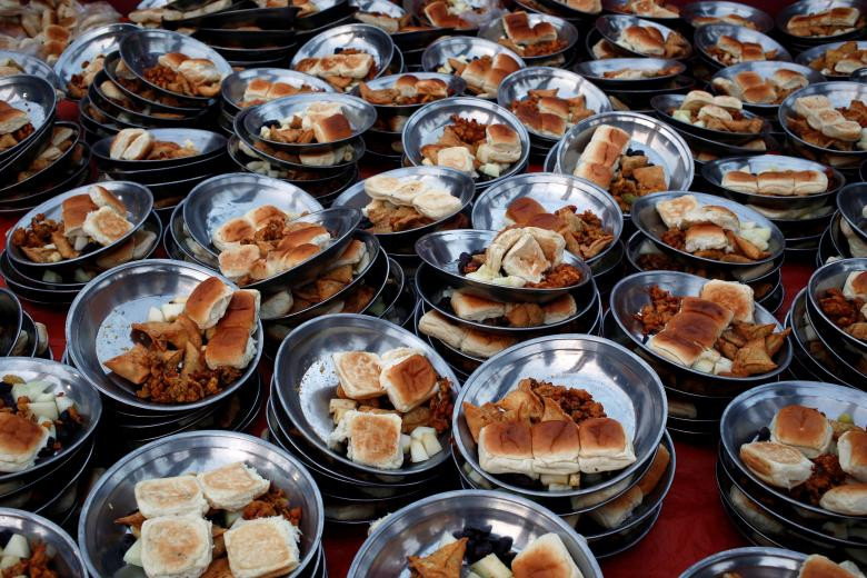 Các đĩa thức ăn chuẩn bị cho bữa sáng tại một nhà thờ Hồi giáo ở Karachi, Pakistan, trong tháng lễ Ramadan. Ảnh: Reuters.