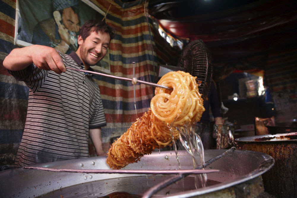 Một người bán hàng đang làm kẹo trong nhà máy để chuẩn bị cho tháng ăn chay tại thủ đô Kabul, Afghanistan. Ảnh: Sputnik.