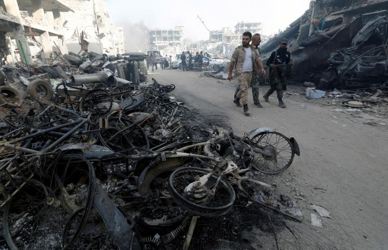 Những chiếc xe bị thiêu rụi trên một con phố ở al-Hajar al-Aswad.