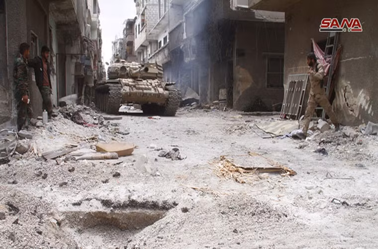 Trong khi đó, hãng thông tấn SANA (Syria) ngày 13/5 đưa tin, Quân đội Syria và Quân đội Tự do Palestine (PLA) tiếp tục chiến dịch quân sự ở khu vực phía bắc quận al-Hajar al-Aswad, qua đó giành lại quyền kiểm soát thêm nhiều tòa nhà xung quanh tòa thị chính của thị trấn này từ tay phiến quân IS. Ảnh: SANA.