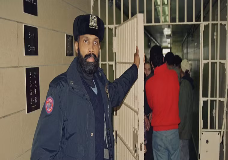 Một nhân viên nhà tù chuẩn bị áp giải các phạm nhân từ tòa án trở về nhà tù Rikers Island ở New York. Ảnh: WB.