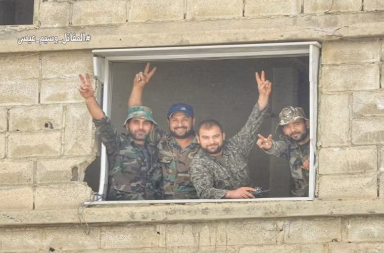 Các binh sĩ Syria giơ tay biểu tượng chiến thắng khi đứng trong một tòa nhà ở Nam Damascus. Ảnh: AMN.