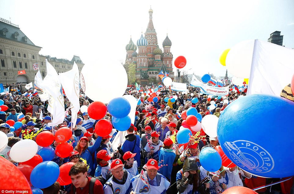 Người dân mang theo cờ, hoa và bóng bay khi tham gia diễu hành ở khu vực Quảng trường Đỏ của thủ đô Moscow.