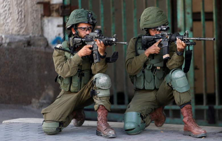 Các binh sĩ Israel chĩa súng về phía người biểu tình Palestine tại Hebron ở Bờ Tây hôm 11/5.