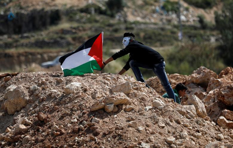 Một người đeo mặt nạ cắm cờ Palestine trong cuộc biểu tình chống Israel gần khu định cư Do Thái Beit El, gần Ramallah, trước dịp kỷ niệm 70 năm ngày Nakba.