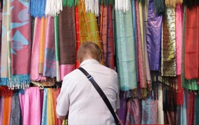 Du khách xem những chiếc khăn được bày bán trong khu chợ ở thủ đô Damascus hồi tháng 10/2010. Ảnh: AP.