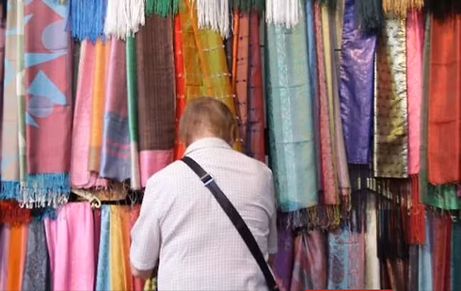 Du khách xem những chiếc khăn được bày bán trong khu chợ ở thủ đô Damascus hồi tháng 10/2010. Ảnh: AP.