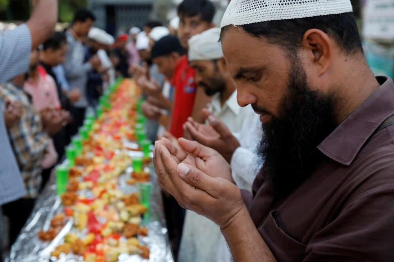Người bán hàng cầu nguyện trường bữa ăn Iftar của tháng ăn chay Ramadan tại một khu chợ ven đường ở Mumbai, Ấn Độ, ngày 22/5.