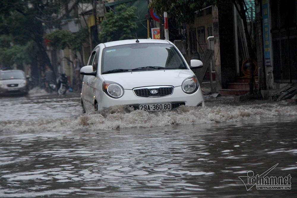 Ô tô rẽ sóng đi vào đường ngập ở Hà Nội.