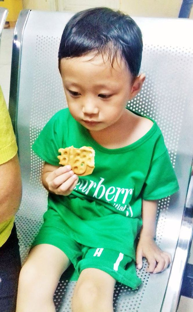 Cháu bé được bà cho ăn trong khi chờ mẹ.