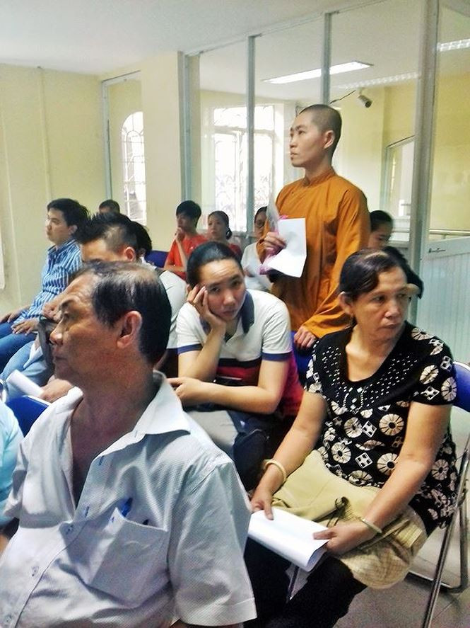 Một nhà sư đứng đợi khá lâu chờ làm hộ chiếu.