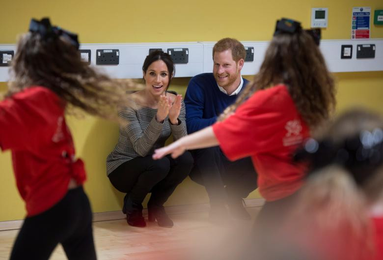 Hoàng tử Harry và Markle chăm chú xem các em nhỏ tập nhảy trong chuyến thăm trung tâm Star Hub ở Cardiff ngày 18/1/2018.