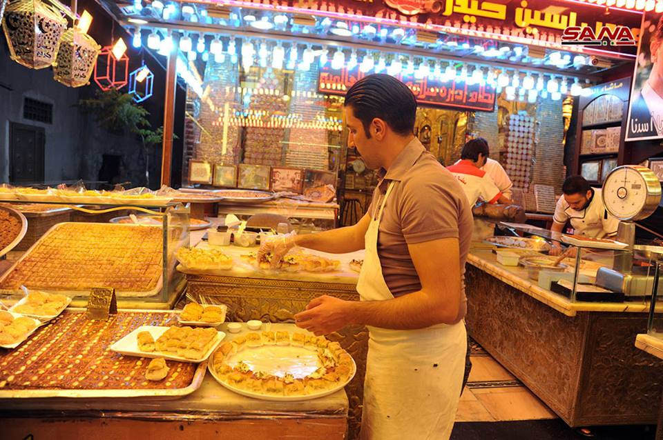Người đàn ông đang chuẩn bị bánh bán cho thực khách. Ảnh: SANA.