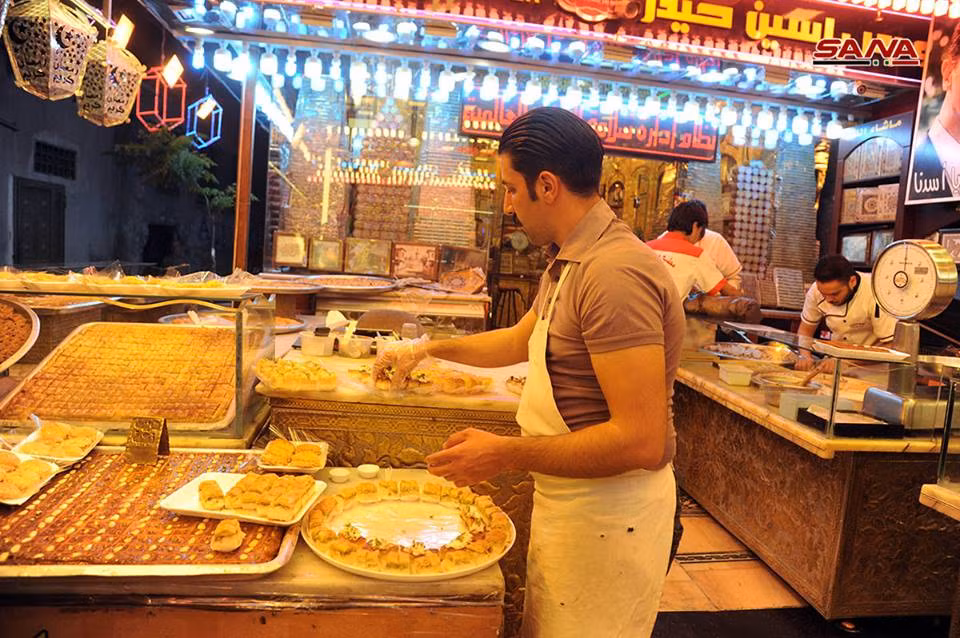 Người đàn ông đang chuẩn bị bánh bán cho thực khách. Ảnh: SANA.