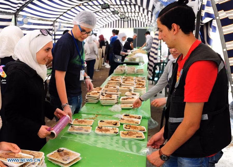 Các tình nguyện viên Syria chuẩn bị đồ ăn để phân phát cho người nghèo và những người dân sơ tán ở thủ đô Damascus hôm 20/5. Ảnh: THX.