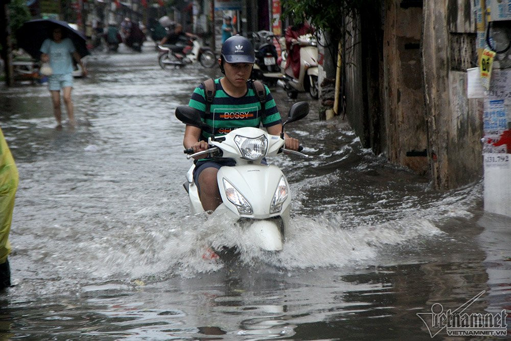 Phố Thanh Đàm (Hoàng Mai) với 2 điểm ngập ở đầu phố và lối dấn lên đê Nguyễn Khoái. Cả tuyến phố chìm trong biển nước từ 17h chiều đến 19h vẫn chưa có dấu hiệu rút khi cơn mưa vẫn kéo dài trút xuống. Ảnh: Người dân đi xe lội sóng qua.