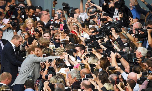 Theo Daily Mail, Hoàng tử Harry được anh trai là Hoàng tử William “hộ tống”, vui mừng bắt tay và trò chuyện với đám đông người hâm mộ Hoàng gia Anh bên ngoài Lâu đài Windsor hôm 18/5. Ảnh: Reuters.