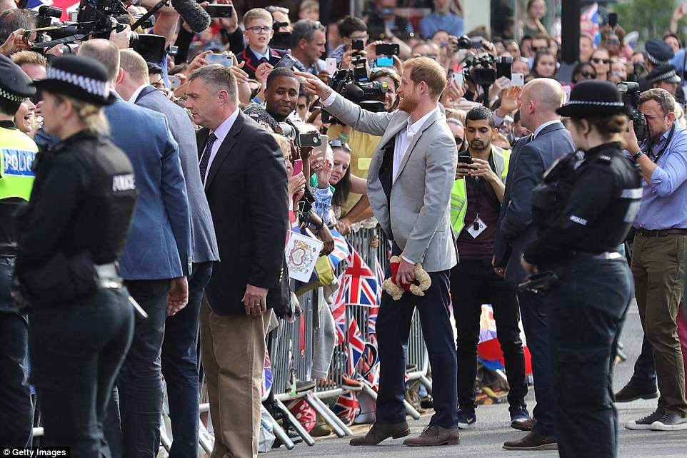 Anh đi giày, mặc quần jacket xám và áo sơ mi màu trắng. Hai vị Hoàng tử Anh luôn được lực lượng an ninh bảo vệ. Ảnh: Getty.