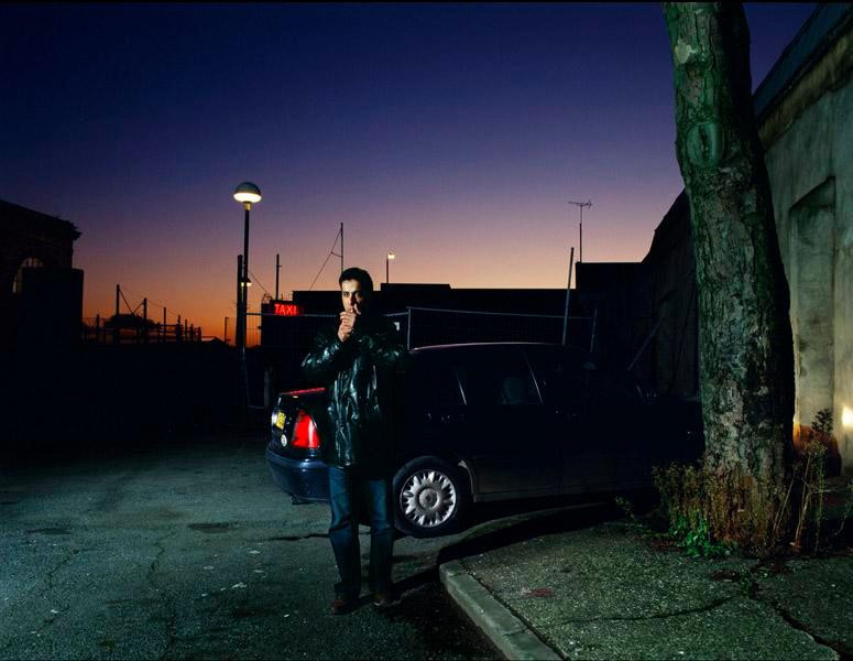 Người đàn ông hút thuốc trên một con phố tối tăm ở London đầu những năm 2000.