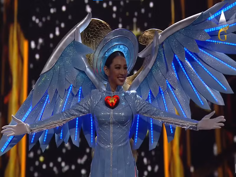 Ở phần kết đêm thi quốc phục, một bên cánh "thiên thần" trang phục của Thùy Tiên không may bị cụp xuống. Gặp sự cố nhỏ, Thùy Tiên xử lý tình huống nhanh và bước vào trong. Sau đêm thi, Thùy Tiên hé lộ hình ảnh hai cánh tay bị thương. Người đẹp chia sẻ trên Ngôi sao, do phần tay áo bị chật nên khi vận động trong hậu trường, cô bị tụ máu. Khi lên trình diễn, Thùy Tiên quyết định bỏ bớt đôi găng tay boxing để dễ dàng vận động. Ảnh: Sen Vàng